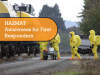 Workers in yellow HAZMAT suits, working next to a line of rail cars on a track.